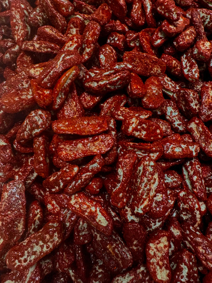 close up of gummies shape up as dill pickles covered in chamoy and chili 