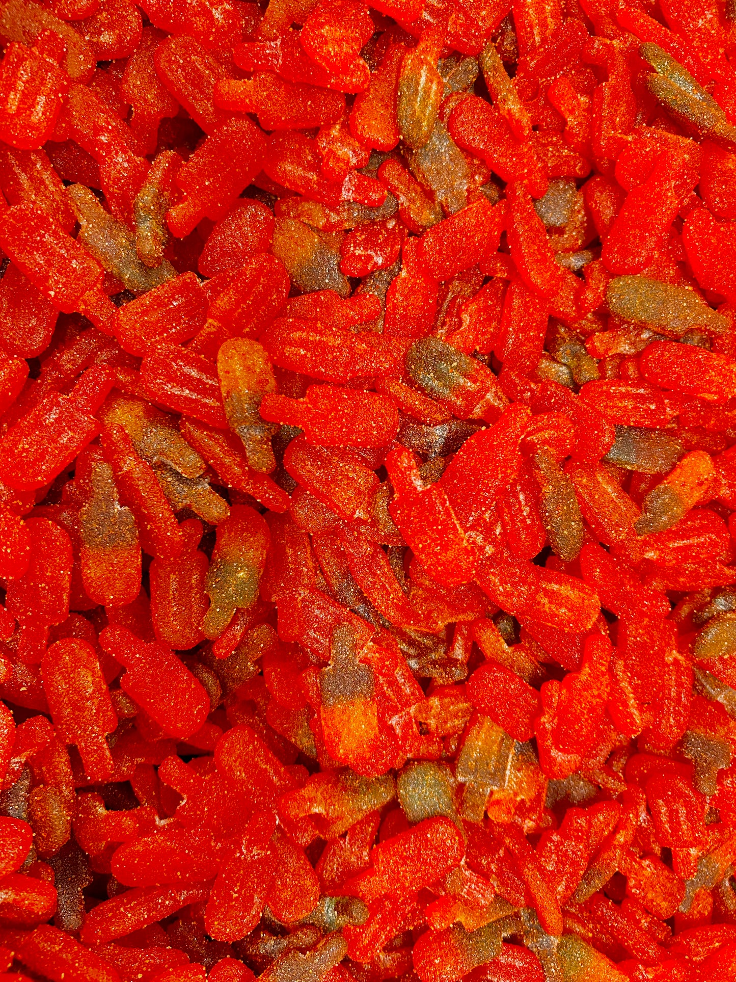 close up of gummies shape up as popsicles covered in chamoy and chili 